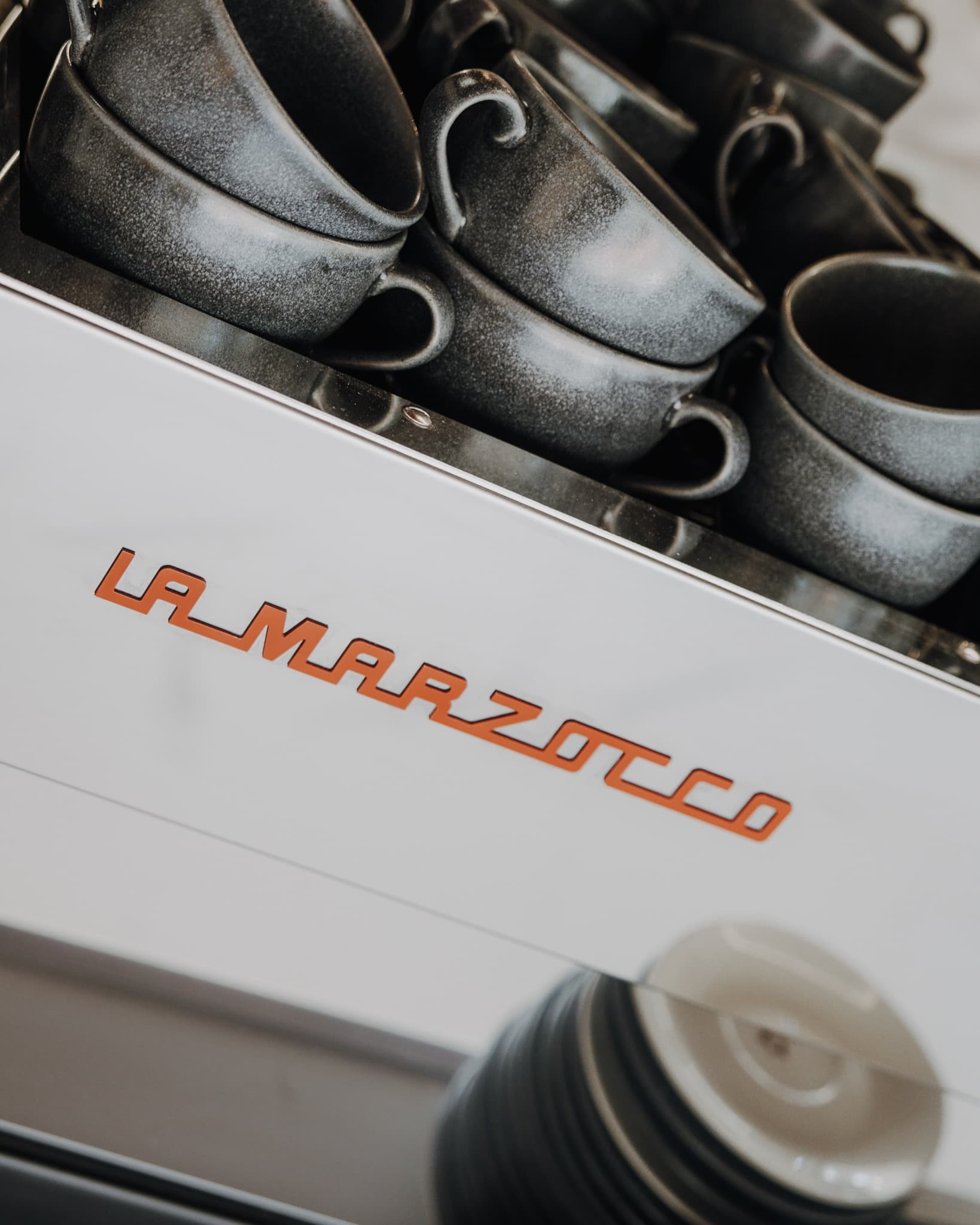 Unsere La-Marzocco-Maschine mit den gestapelten Steinguttassen